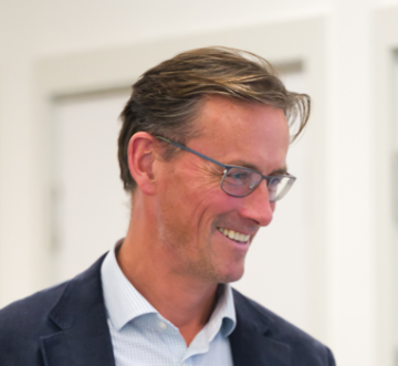 A man looking to the right and smiling