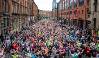 A street full of charity runners all looking at the camera waving their hands