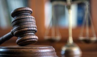 A gavel and block, in a courtroom setting