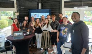 A group of people standing together in a room and smiling