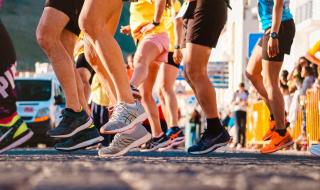 The legs of a group of runners waiting to start a sponsored run