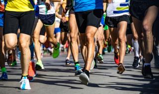 The legs of a crowd of runners at a sponsored run