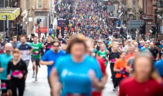 A huge crowd of people running through a street as part of a sponsored run