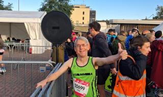 A man in running gear smiling and doing a thumbs up