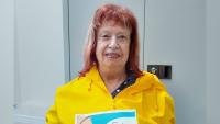 A woman holding up a poster and smiling