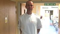 A uniformed man standing in a hospital corridor