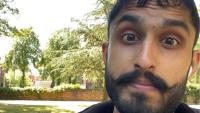 A close up of man's face in a park