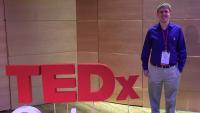 A man standing next to a logo saying 'TED x'