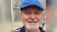 A man wearing a cap and smiling