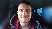A man sitting in a car and smiling