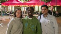 A woman and two men standing side by side and smiling