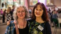 Two women standing next to each other and smiling