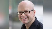 A man in glasses smiling