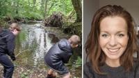 Two boys next to a woodland stream. A smiling woman's face is net to them