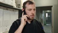 A man speaking into a telephone and looking frustrated