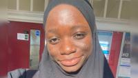 A woman in a headscarf, smiling