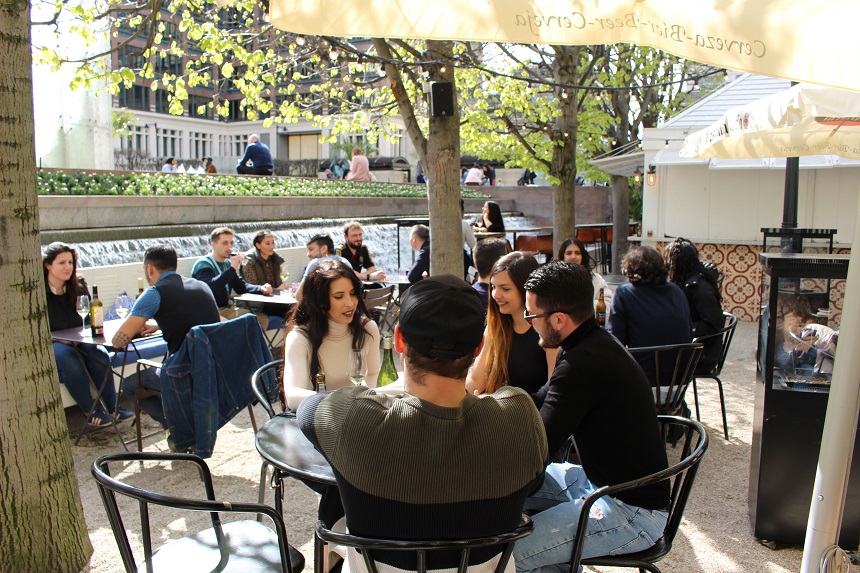 An outdoor restaurant scene, with people sitting at tables