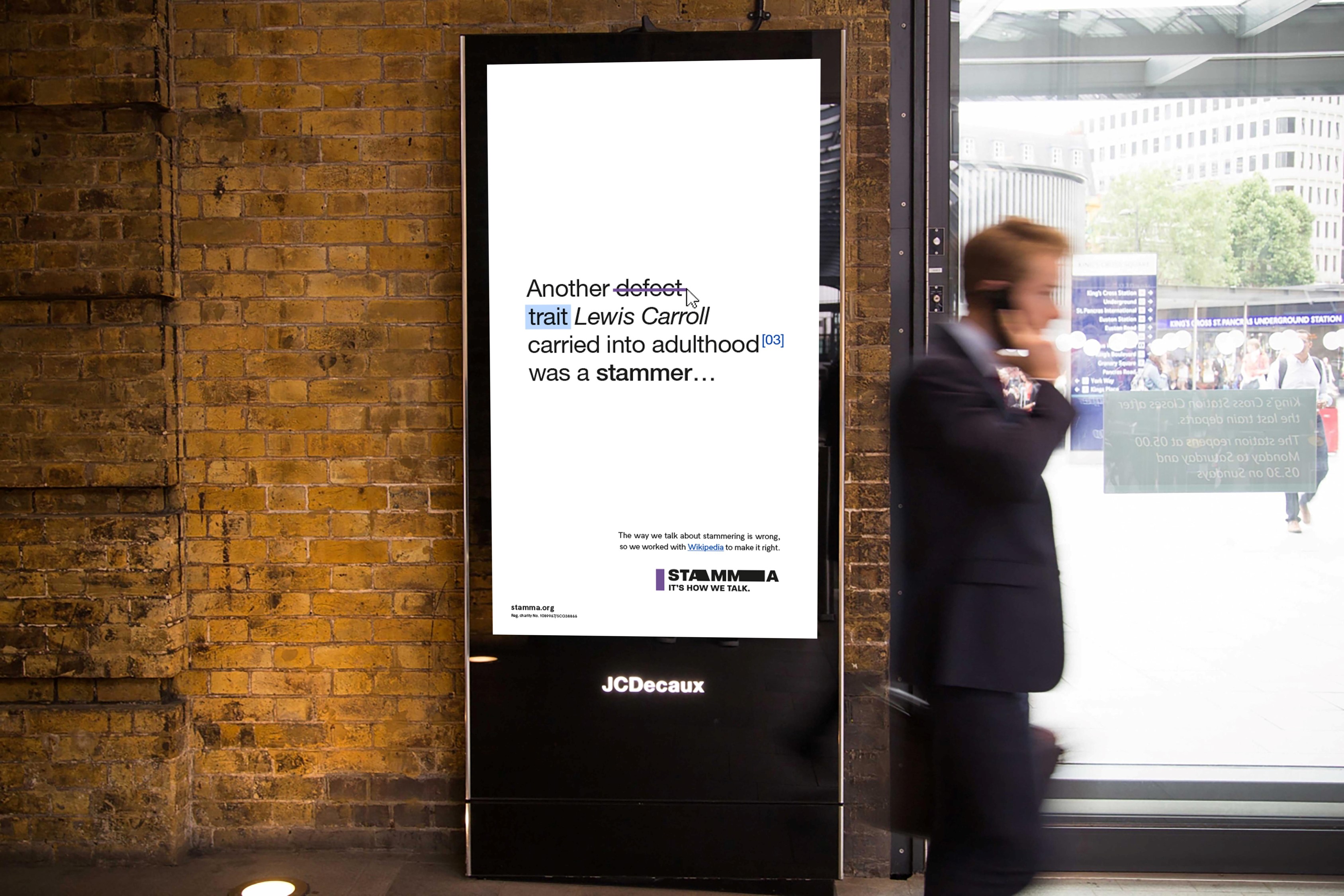 One of STAMMA's outdoor digital advertisements, with a man passing by