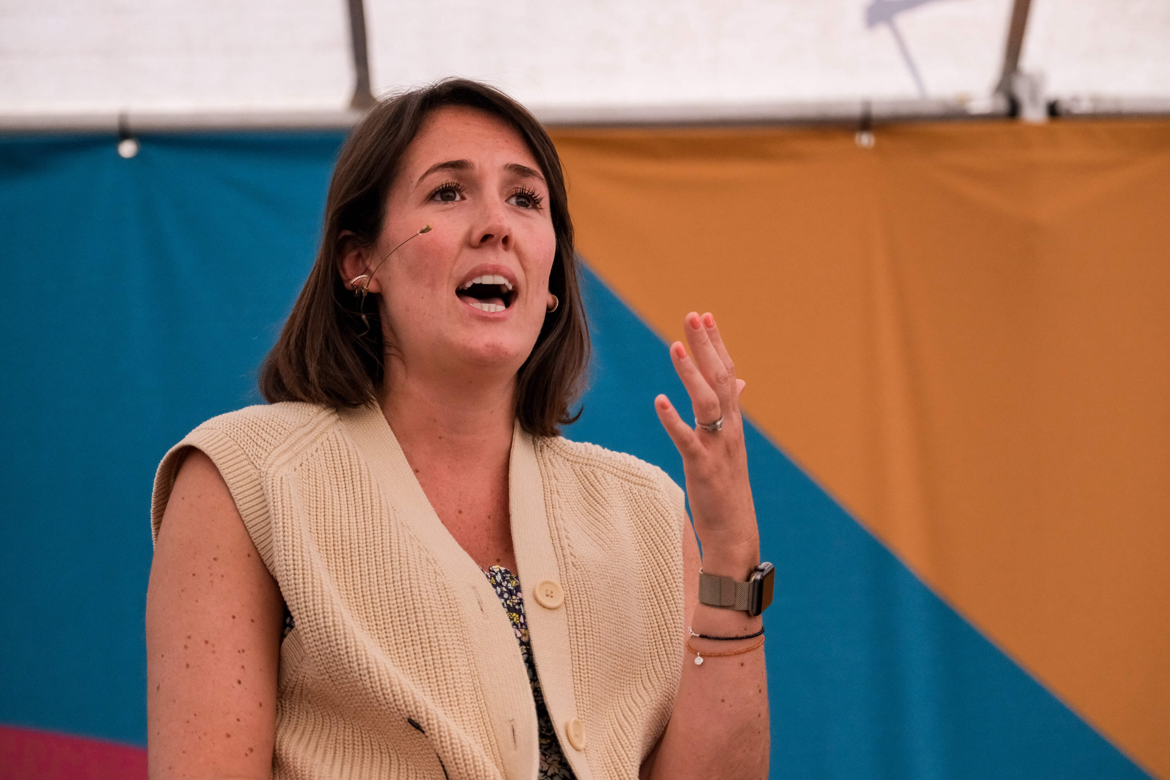 A woman speaking with a hands-free microphone