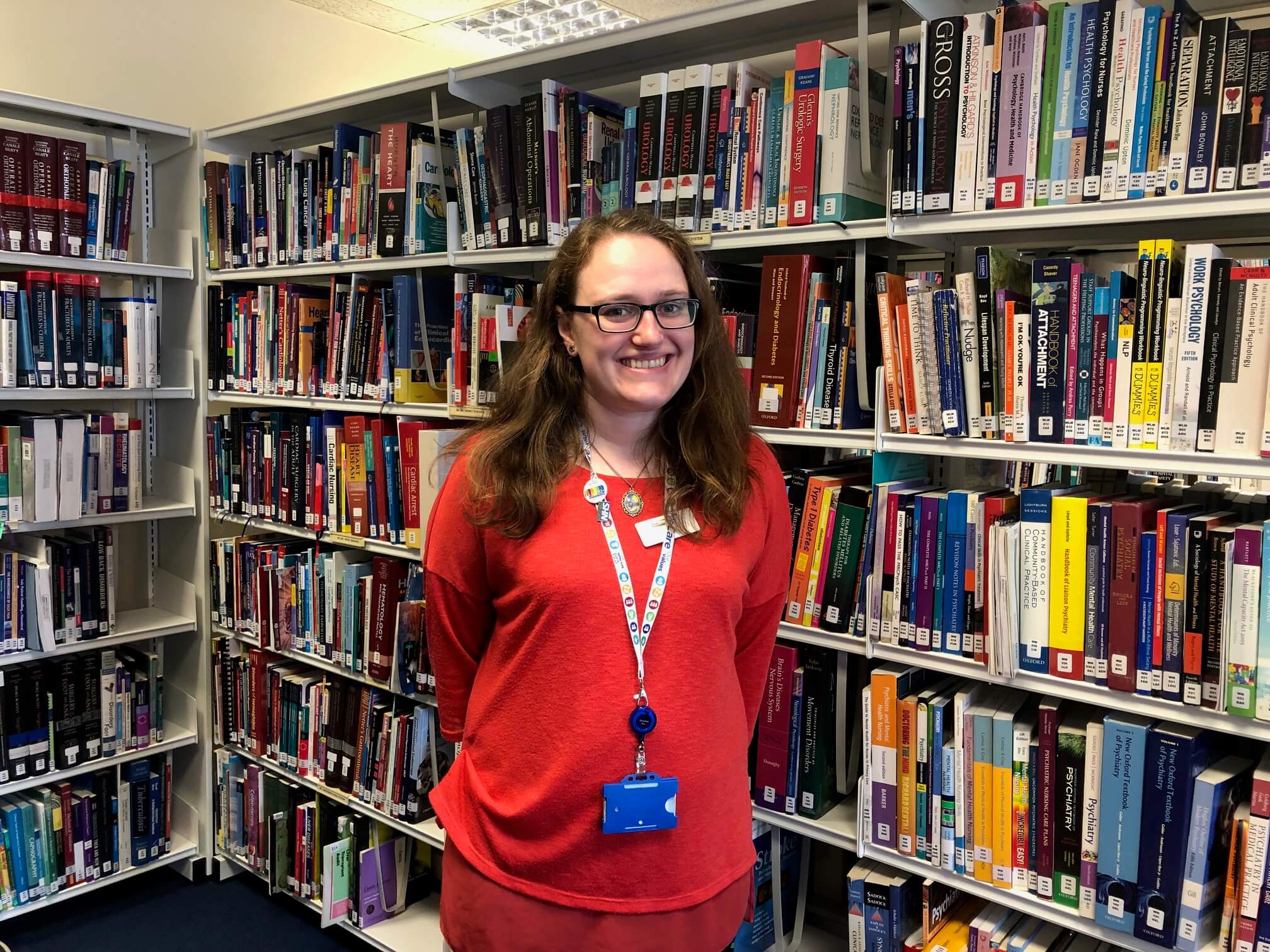A woman standing in front of bookshelves, looking at the camera