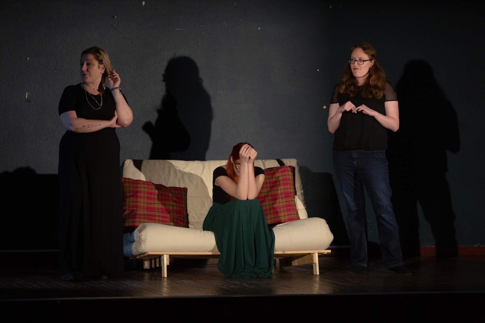Three women on stage performing a play