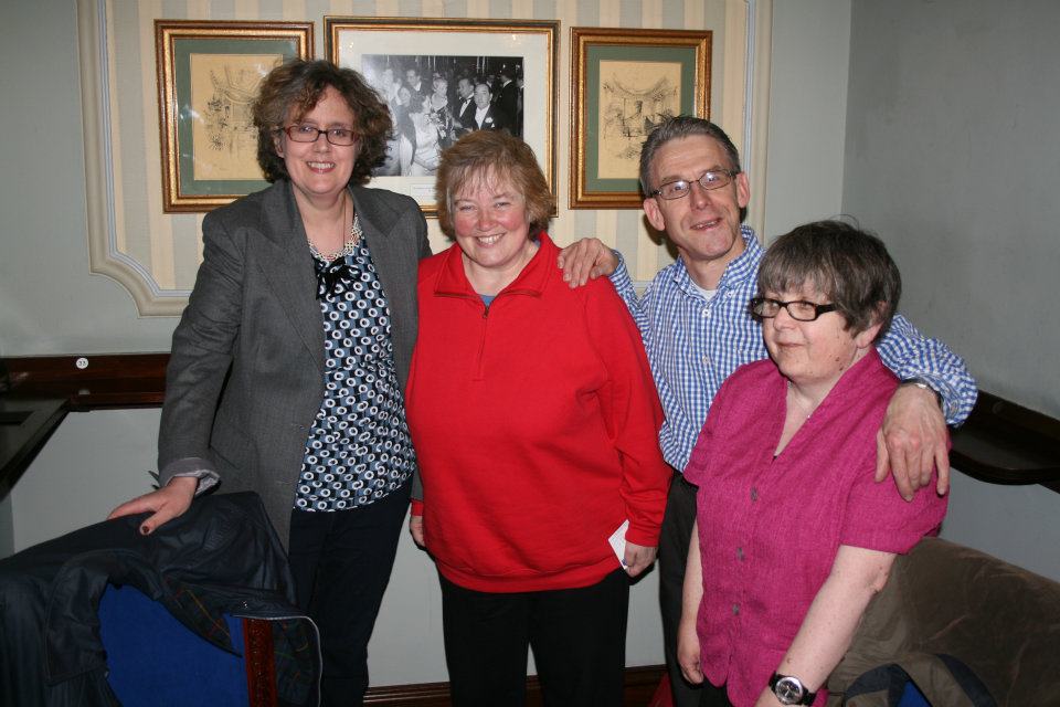 Four people looking at the camera and smiling