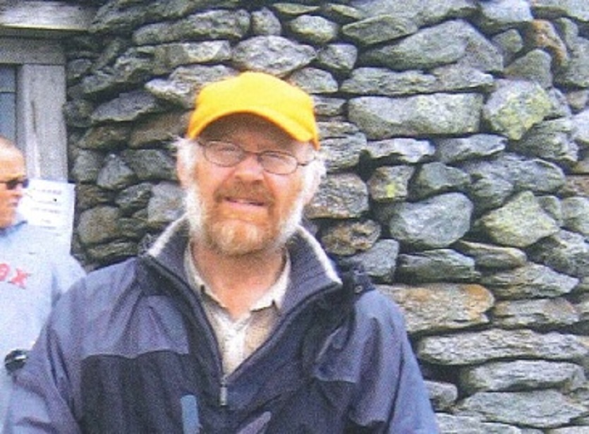 A man in a baseball cap looking at the camera