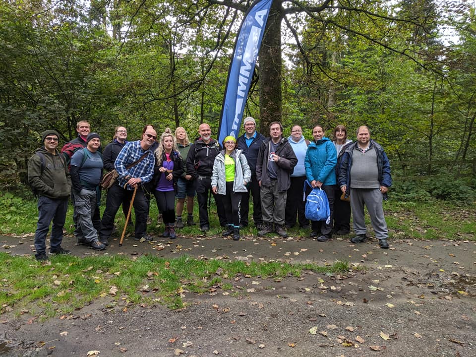 A group of ramblers in a woodland setting looking at the camera and smiling