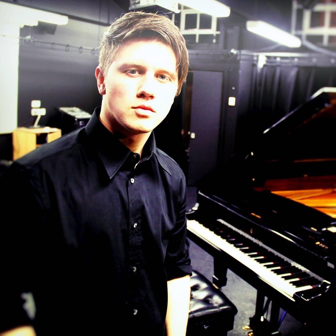 Jordan beside a piano