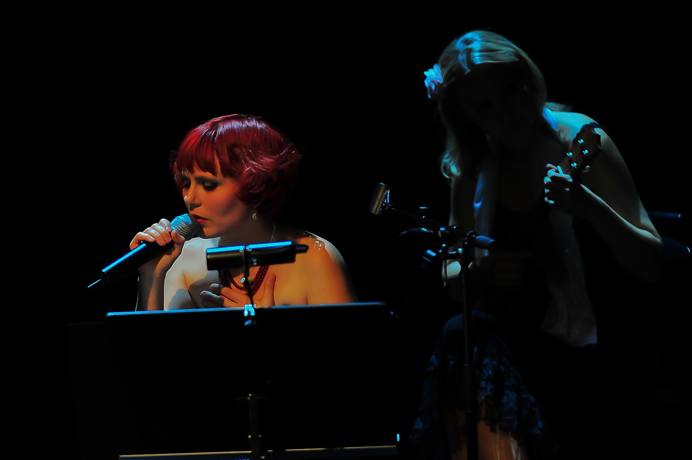 A woman singing into a microphone on stage