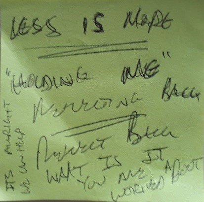 A post it note, with scribbled writing.