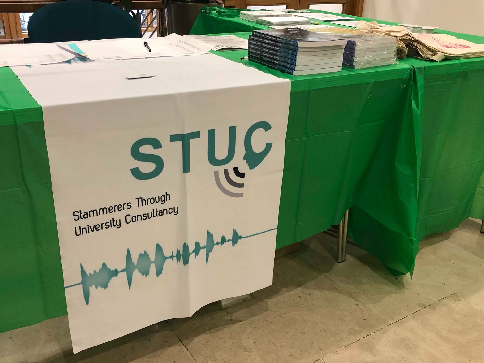 An information stall with a sign saying 'STUC: Stammerers Through University Consultancy'