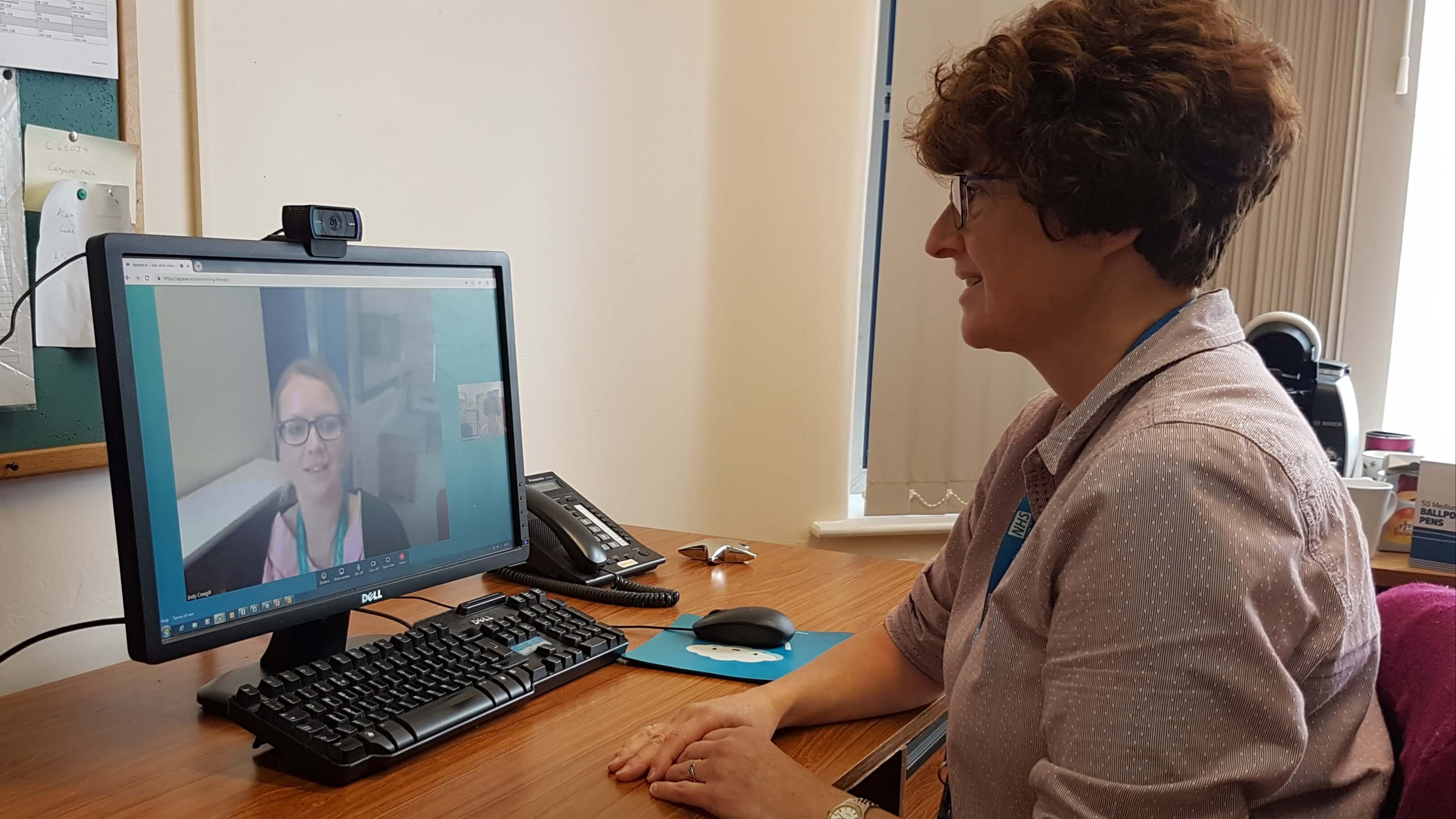 A woman in a therapy setting speaking to someone else via a video call